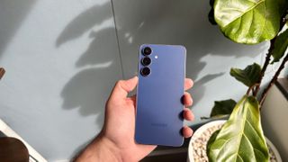 Samsung Galaxy S25 FE being held display-down 