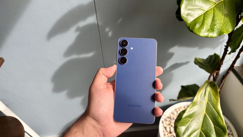 Samsung Galaxy S25 FE being held display-down 