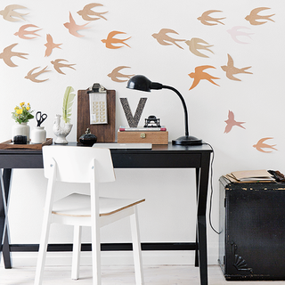 room with bird printed white wall and flower in vase