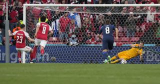 Finland goalkeeper Lukas Hradecky, right, saves a penalty from Denmark's Pierre-Emile Hojbjerg