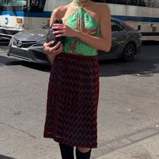 Eliza Huber wearing a green halter top and red skirt from Tory Burch.