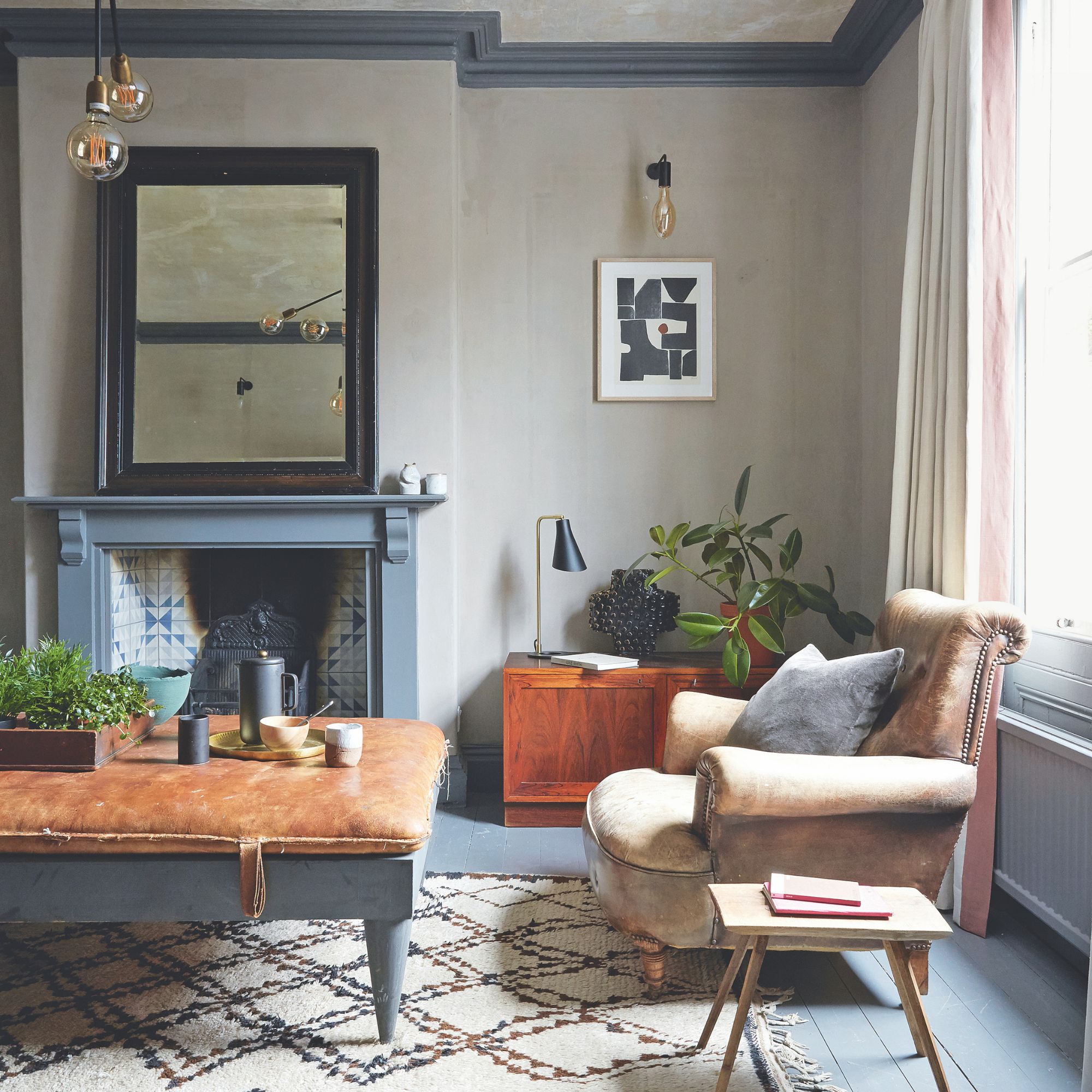 A grey living room with vintage style furniture and abstract artwork