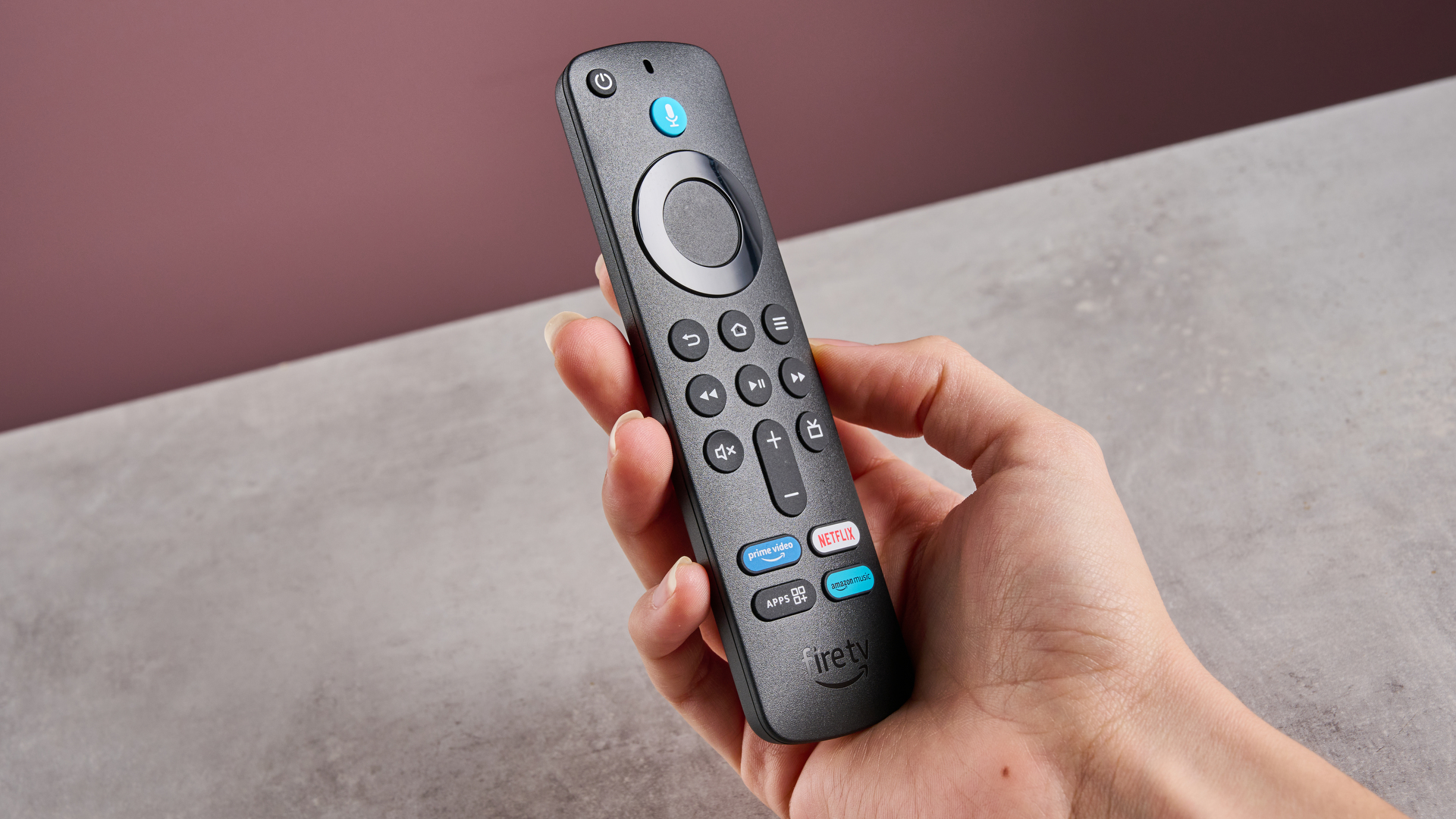 A woman holds the remote control of the Amazon Fire TV Stick HD.