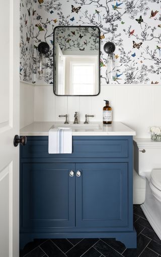 blue powder room vanity, black mirror and wall lights, butterfly wallpaper