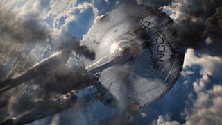 Still from the movie Star Trek into Darkness. Here we see a badly damaged USS Enterprise starship crashing through the cloudy blue sky.
