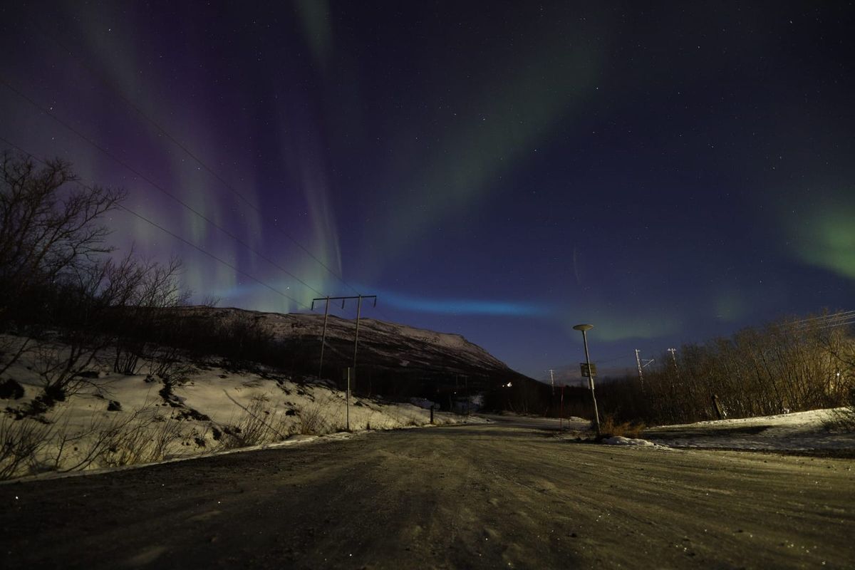 blue ribbon of light appearing over Abisko National Park, Sweden.