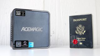 The ACEMAGIC F2A next to a passport for scale