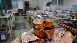 Traditional methods are used if it can ensure the best results. Here, hide glue simmers in copper pots, while a craftsman checks on weighted down tops