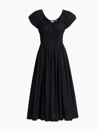 a black ruched doen dress in front of a plain backdrop