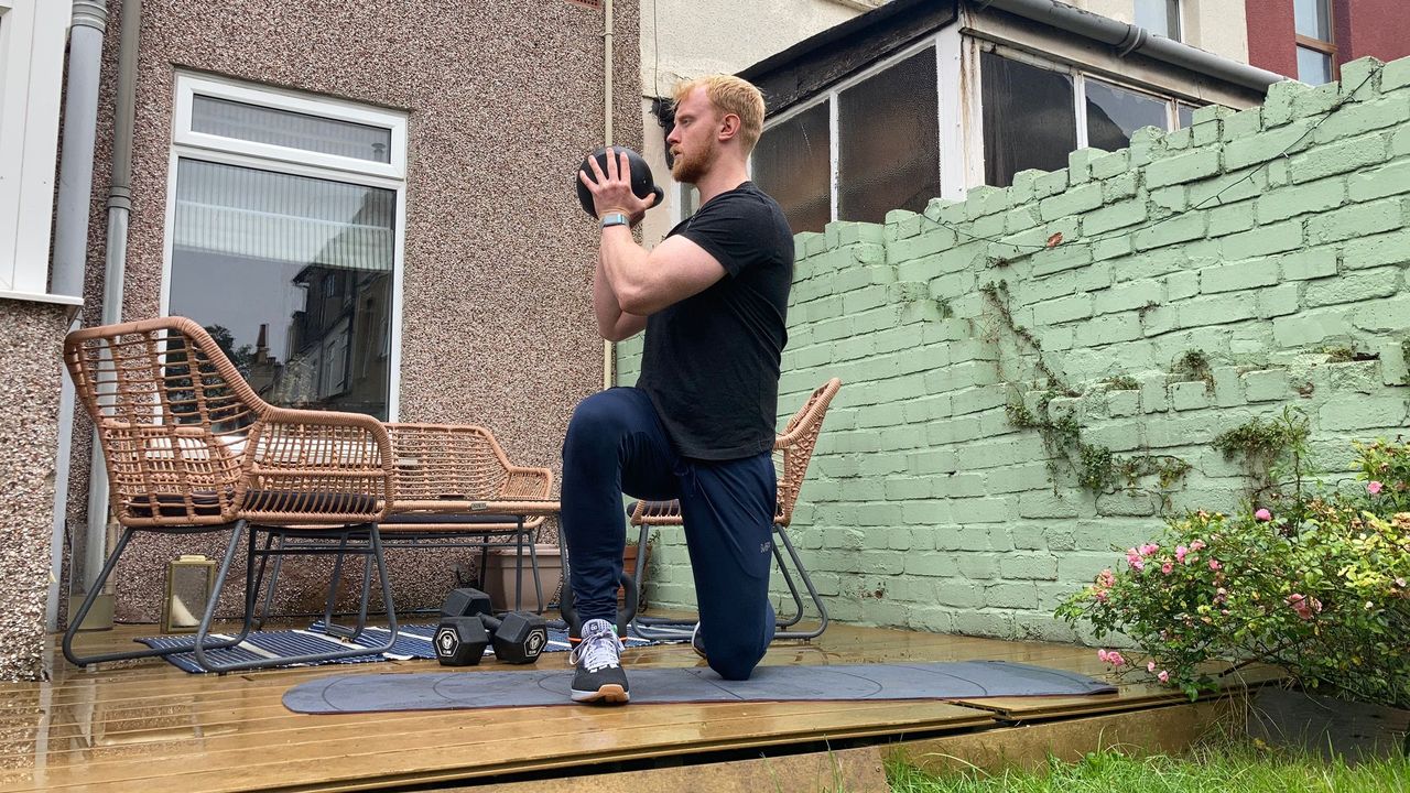 Fit&amp;Well fitness writer Harry Bullmore performing a half-kneeling kettlebell rotation