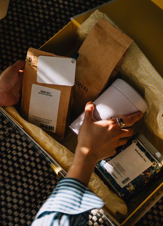 Woman unwrapping a coffee subscription box