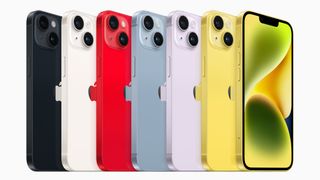 Seven iPhone 14s lined up in a range of colours