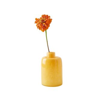 A yellow vase with an orange flower