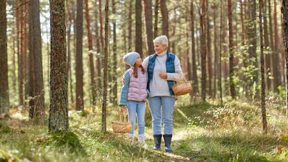 grandmother and granddaughter with baskets in forest