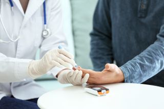 Doctor samples the blood of a patient with diabetes.