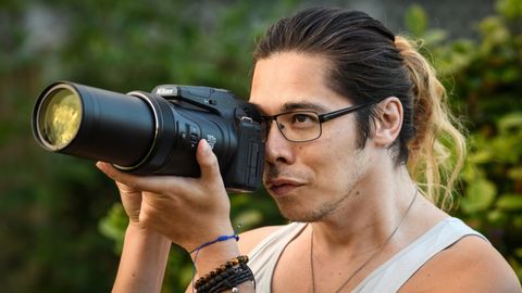 Man taking photo using Nikon Coolpix P1000