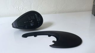 The HP 925 ergonomic vertical mouse on a white desk beside a detached palm rest