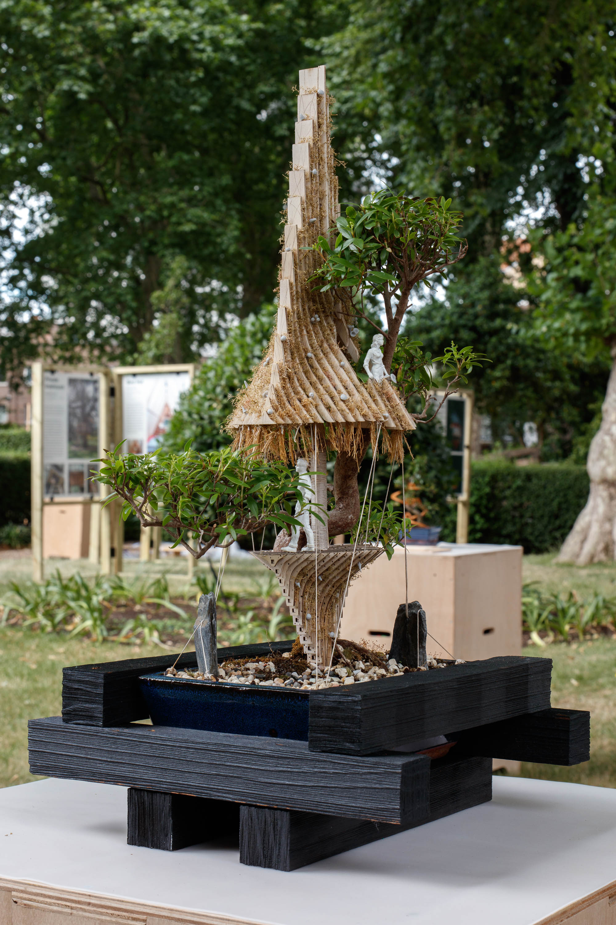view of miniature houses in a park as part of an open air Bonsai treehouse exhibition in London
