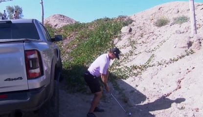Henson hits a wedge shot next to a pickup truck