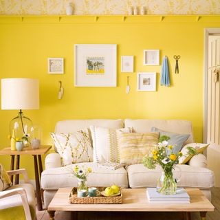 Yellow living room with cream sofa and gallery wall