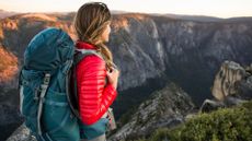 A woman out hiking in the mountains with a backpack on her back