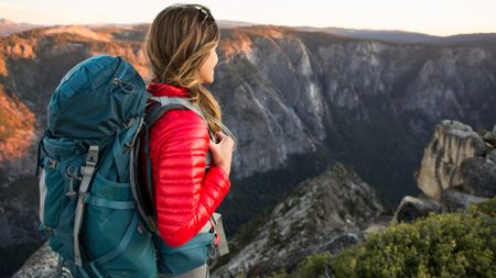 A woman out hiking in the mountains with a backpack on her back