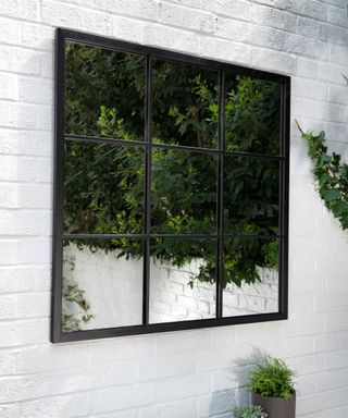 garden mirror on white brick wall