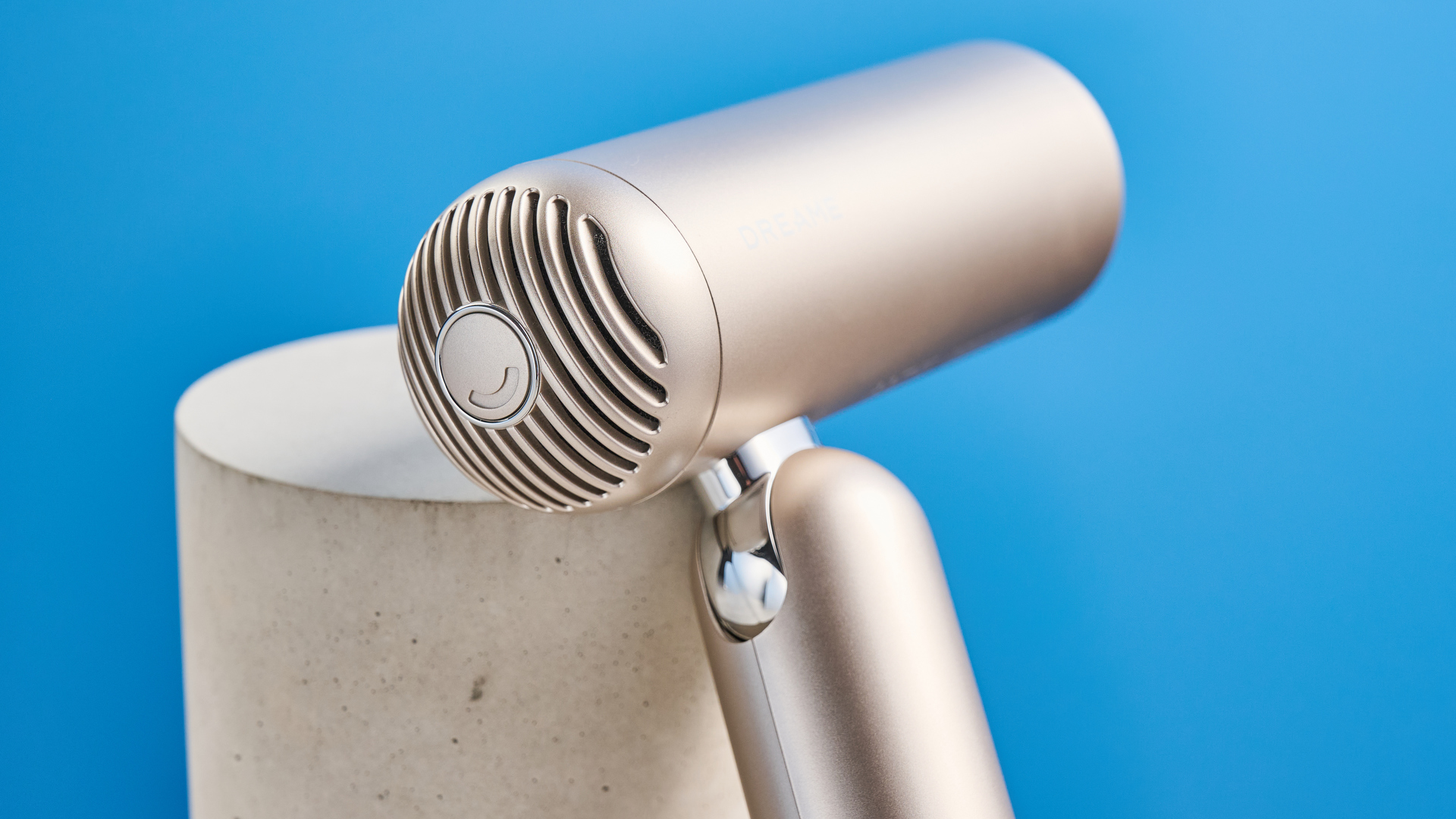 The Dreame Pocket Neo in gold photographed in front of a blue background.