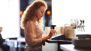 woman using a POS system in a restaurant