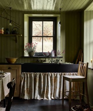 green cottage kitchen with color drenched walls and a cafe curtain