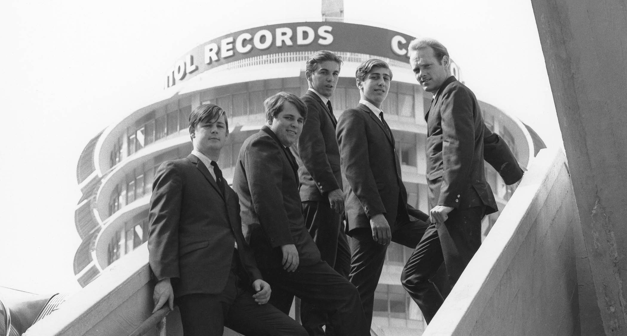 The Beach Boys photographed in 1962 with the Capitol Records building in the background.