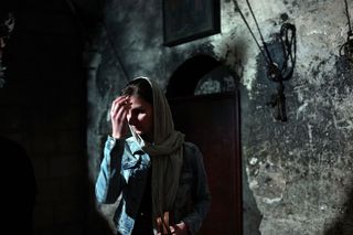 A woman crosses herself in the Church of the Holy Sepulchre in November 2014. The site was identified as a holy shrine by Helena, mother of the first Christian Roman emperor Constantine, in A.D. 326. The Edicule structure was built over the remains of the