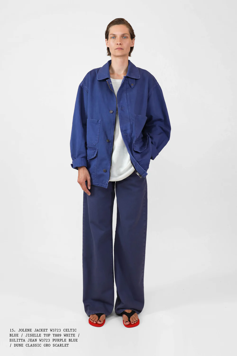 A woman in The Row Spring 2025 wearing jeans, flip-flops, a white tee shirt, and blue shacket
