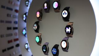 A circular wall display of Samsung Galaxy Watch 5 models and watch bands