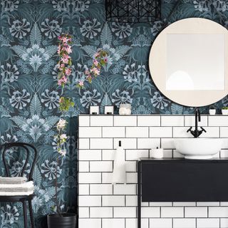 bathroom with wallpaper wall and washbasin with round mirror