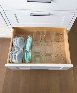 A drawer with tupperware tubs and lids separated