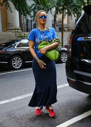 Rihanna walks in new york city wearing an im retired t shirt dress by connor ives with puma sneakers