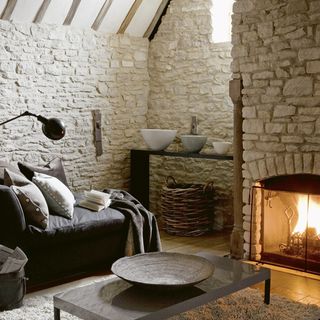 living room with stone walls and fireplace