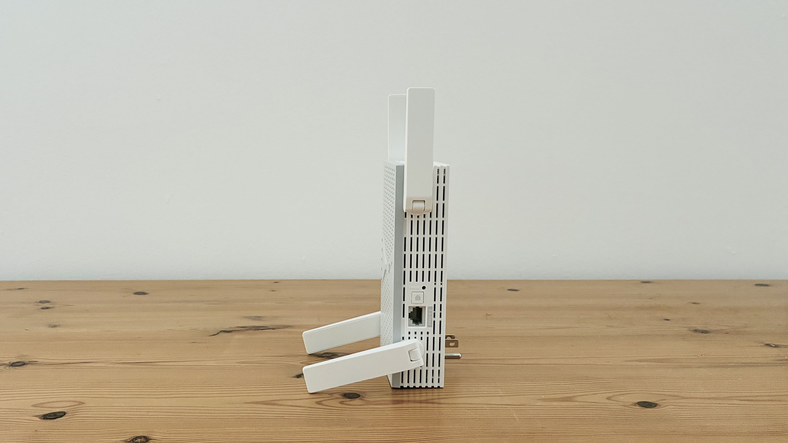 TP-Link BE6300 Wi-Fi extender on wooden desk