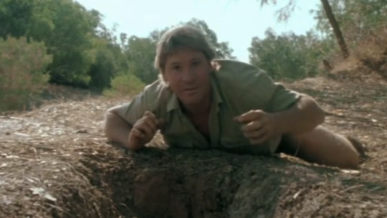 Steve Irwin laying in front of a hole in The Crocodile Hunter: Collision Course