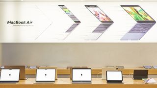 En Apple Store med ett gäng MacBook Air-modeller som står uppradade på långa träbord.