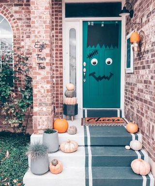 Terraced home with green door decorated at Halloween to depict a Frankenstein like character with pink pumpkins