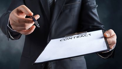 Hands holding a pen and blank contract