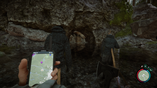 Sons of the Forest - a player looks at the cave entrance shovel location on their GPS