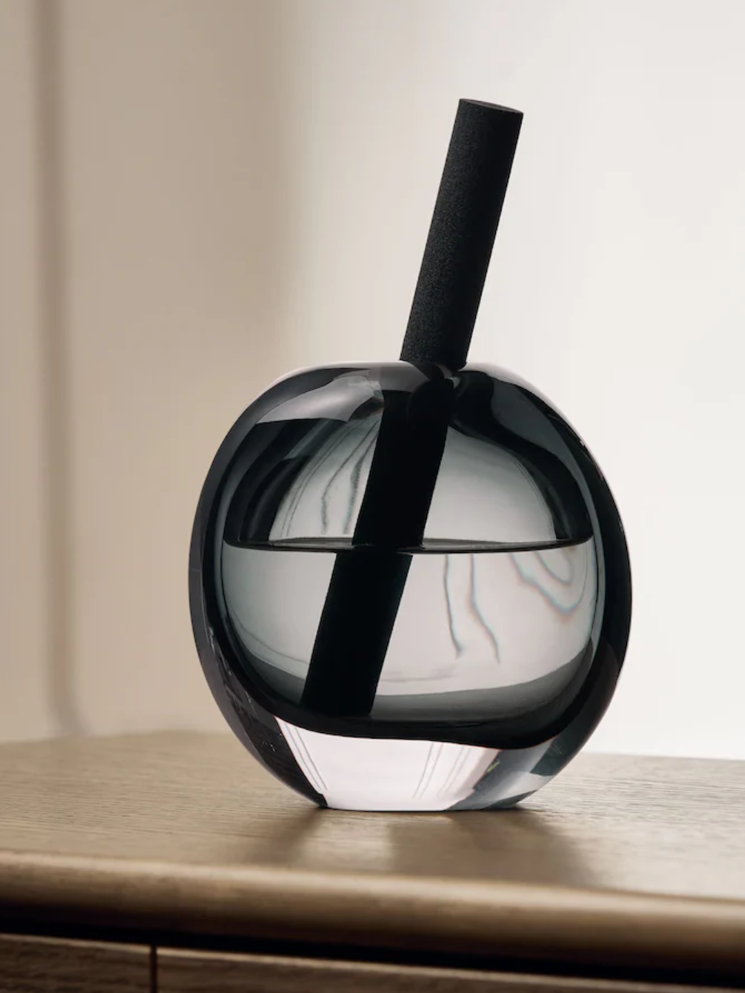 A smokey glass diffuser with a single reed and black tea scent from Next
