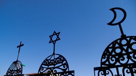 Symbols of Christianity, Judaism and Islam are seen in a display.