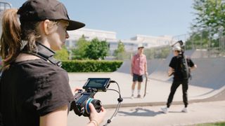 Arri Hi-5 SX by a skate park being used by a woman with a baseball hat