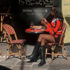 @_livmadeline wearing black riding boots with shorts and a red polo sweatshirt