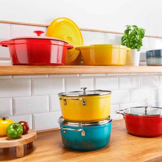 colourful cast iron cookware on wooden shelves