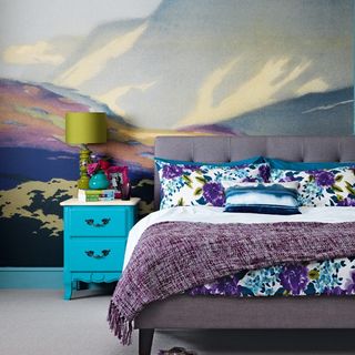 bedroom with floral cushions and blue side table